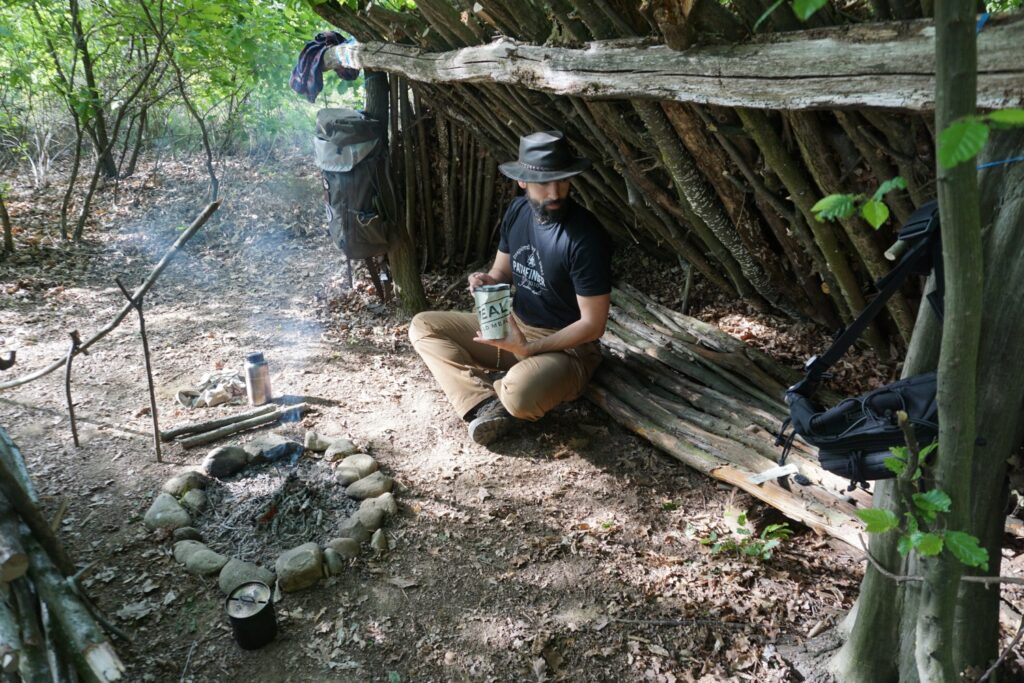 man under constructed wood house enjoying real turmat breakfast