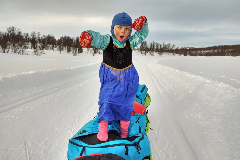 Mina leker på en pulk i snøen