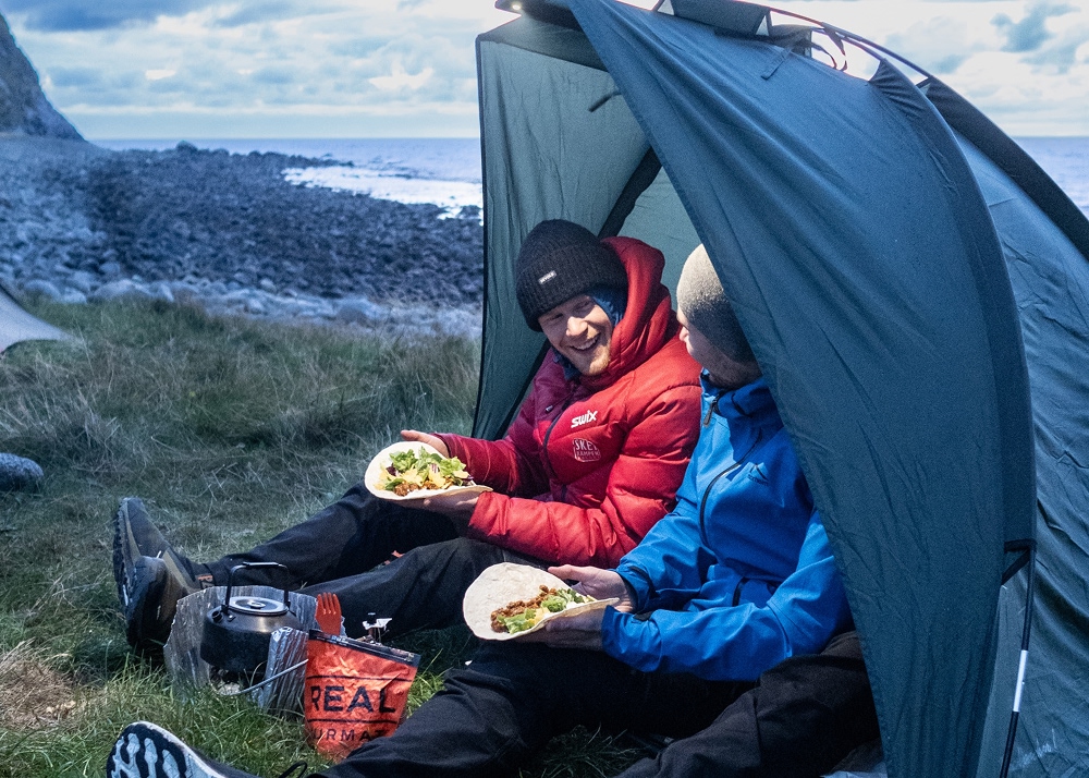 two persons in a semi tent eating real turmat taco bowl 1