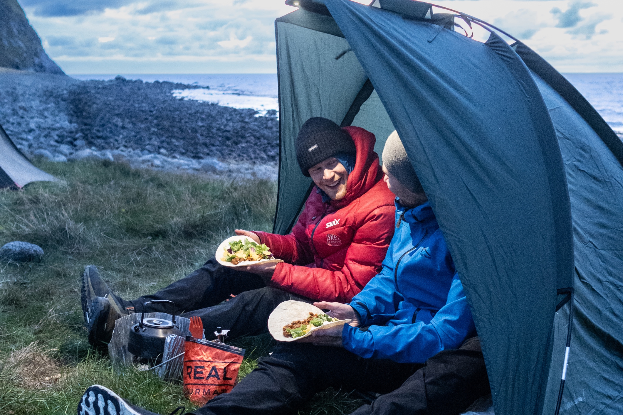 two persons in a semi tent eating real turmat taco bowl