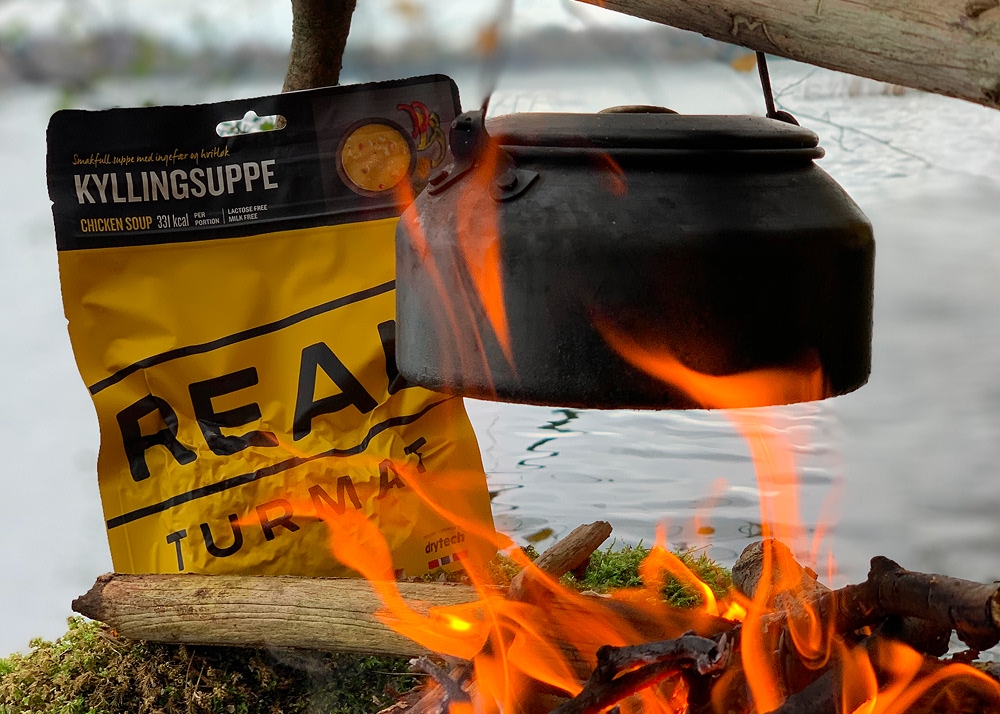 tea kettle over campfire with real turmat soup in the background